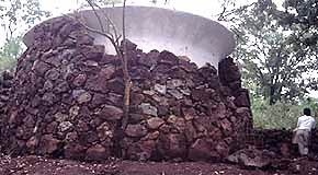 Large rain water cistern with roof wings to increase cistern roof catchment area.