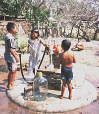 Playing in the drinking water from the finished well.